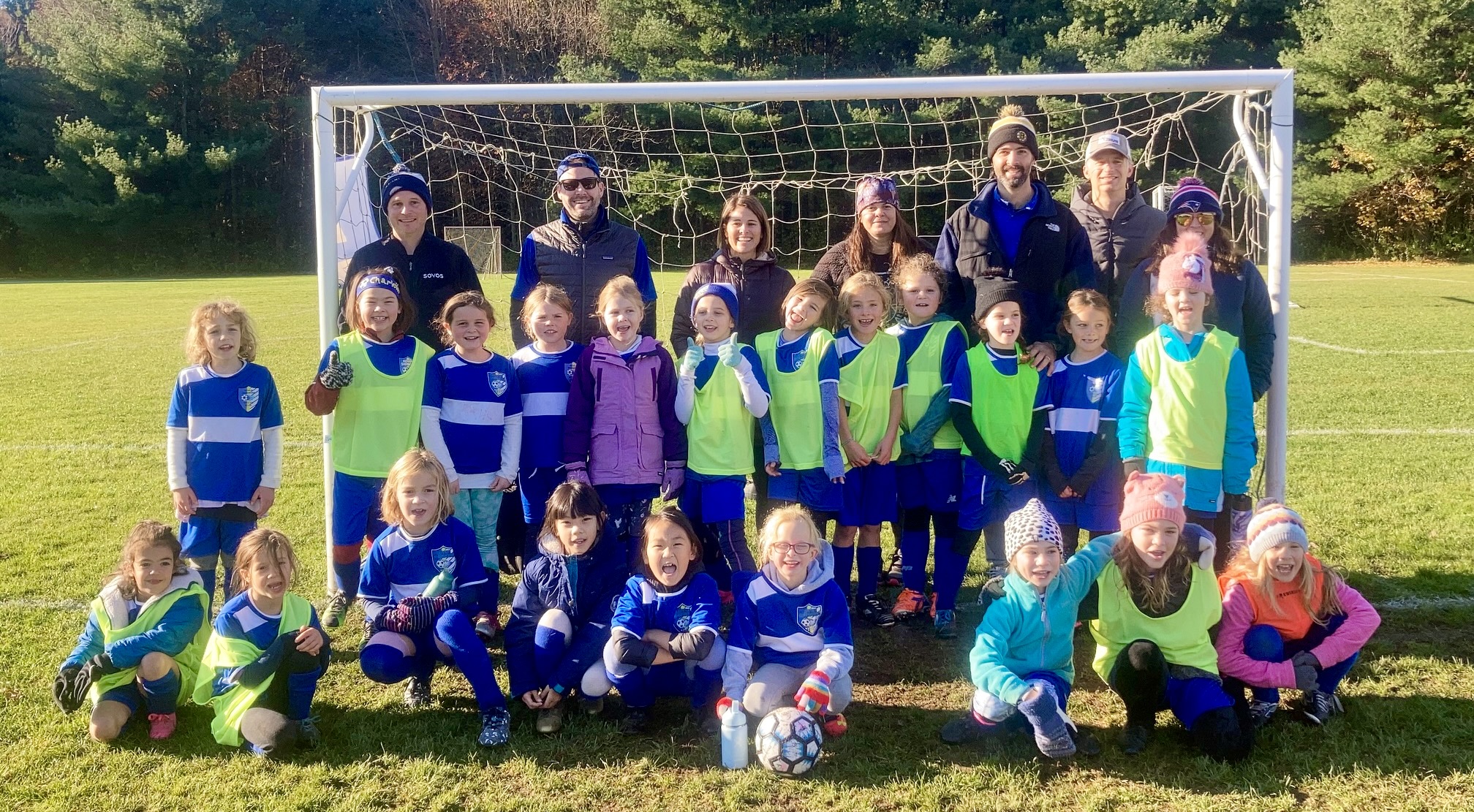 Second grade team posing for a picture in front of the goal net